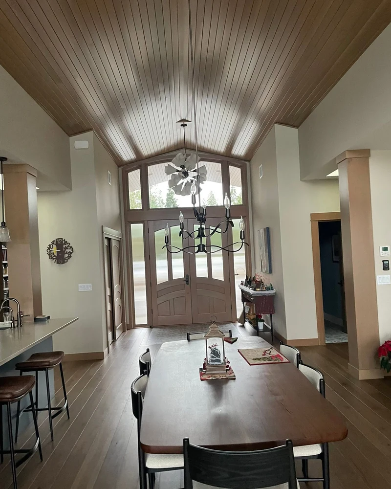 Vaulted tongue-and-groove ceiling, wood entry doors, and hardwood flooring in a custom home by CKS Builders LLC