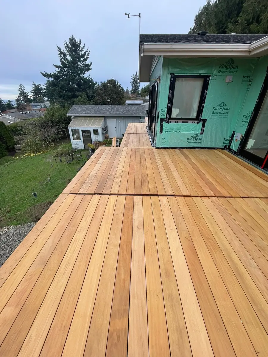 New cedar decking laid outside a structure still wrapped in building paper, by CKS Builders LLC in Port Angeles, WA