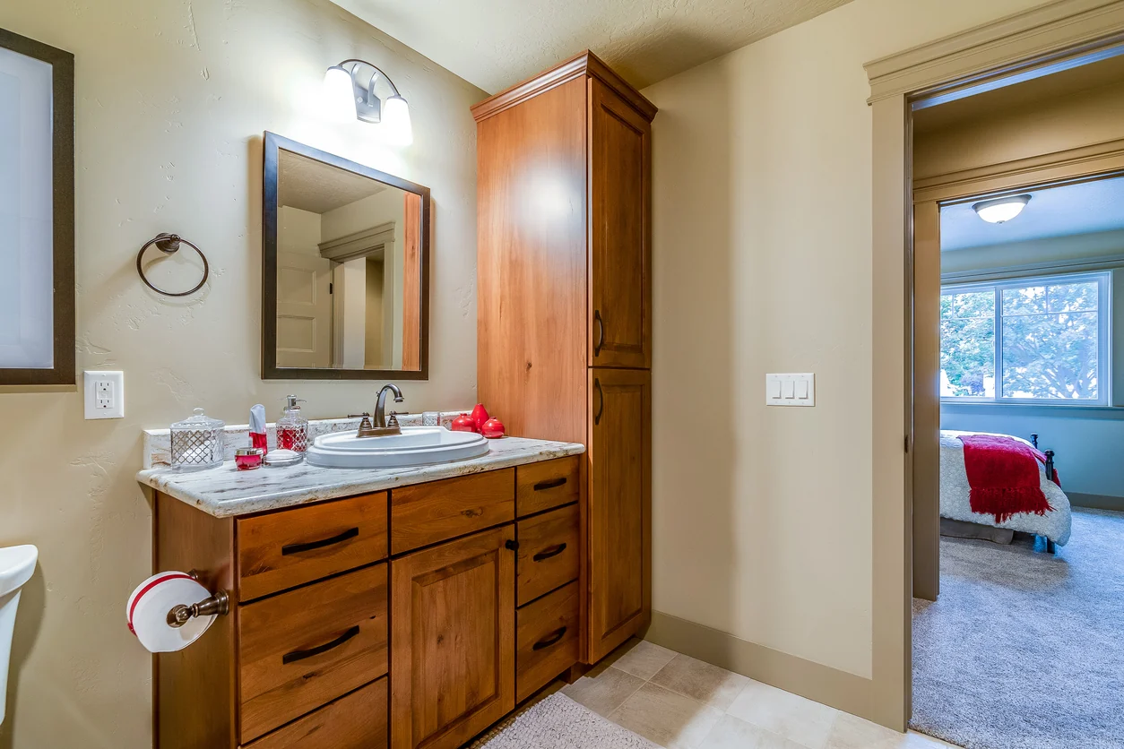 Dated bathroom with a wood vanity, a framed mirror, and limited storage