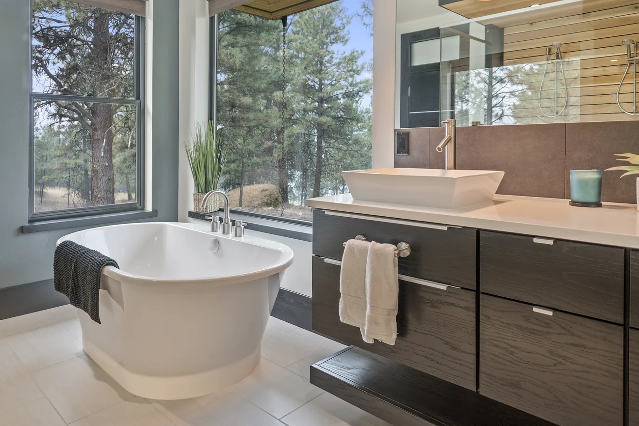 Added primary suite bathroom with a freestanding tub beside a floating vanity and a vessel sink