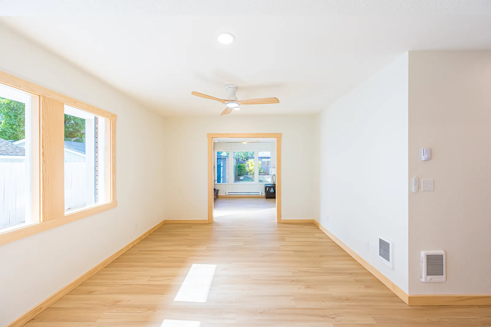 Open dining area with wood-trimmed windows and light wood-look flooring in a home remodeled by CKS Builders LLC