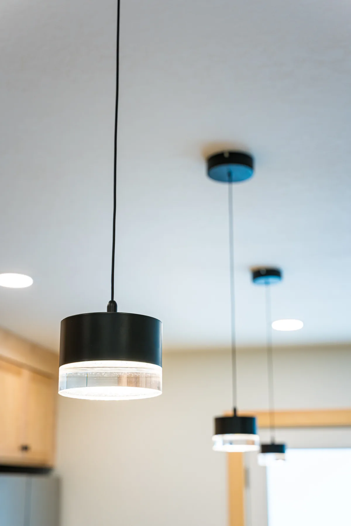 Black pendant lights hung above a kitchen island in a remodel by CKS Builders LLC