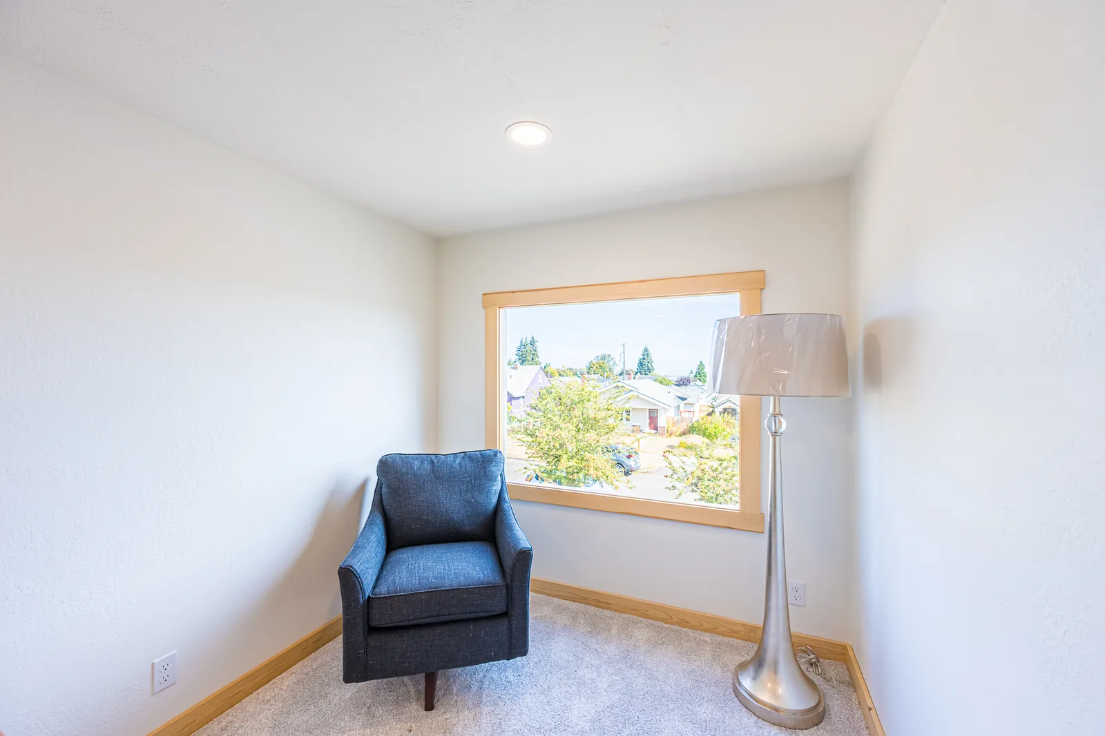 Small carpeted room with an armchair beside a wood-trimmed window in a home remodeled by CKS Builders LLC
